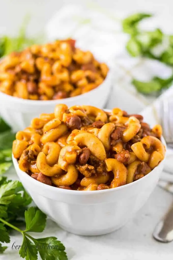 The finished chili mac served in large white bowls.