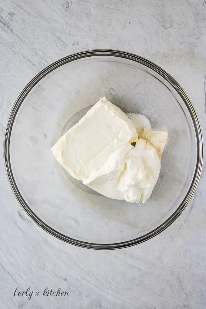 Cream cheese, sour cream, and spices in a mixing bowl.