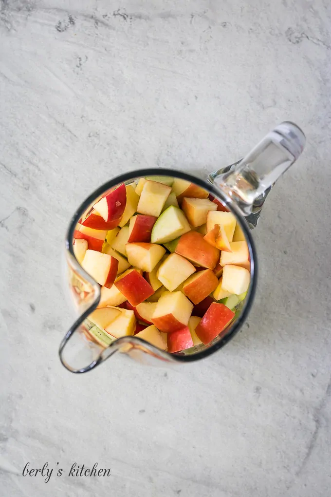 The apples have been diced and placed into a pitcher.