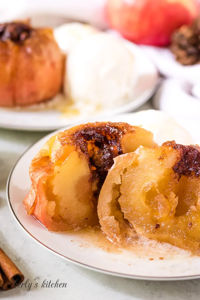 The baked apple has been cut in half to show the center.