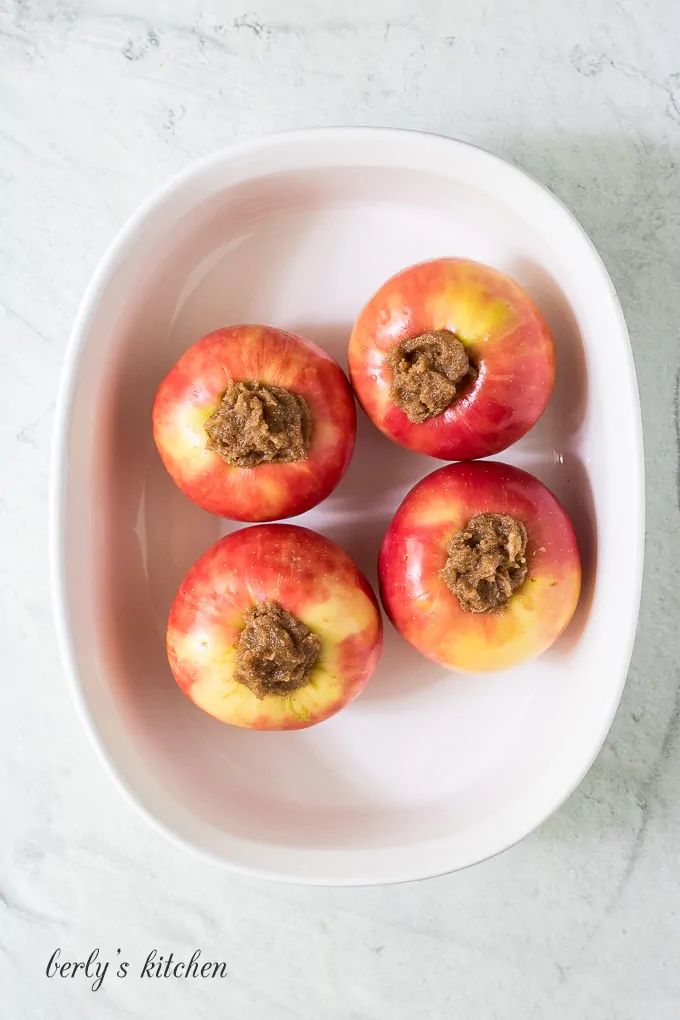 The four apples have been stuffed with the butter mixture.