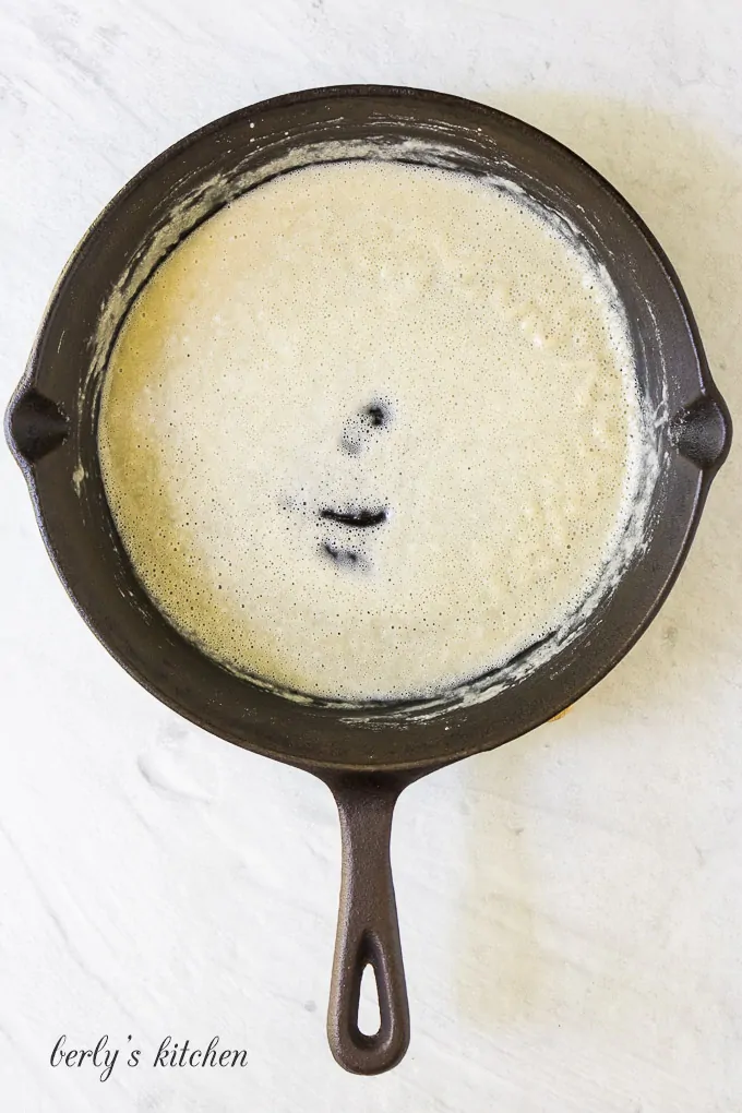 The flour and butter mixture cooking in an iron skillet.