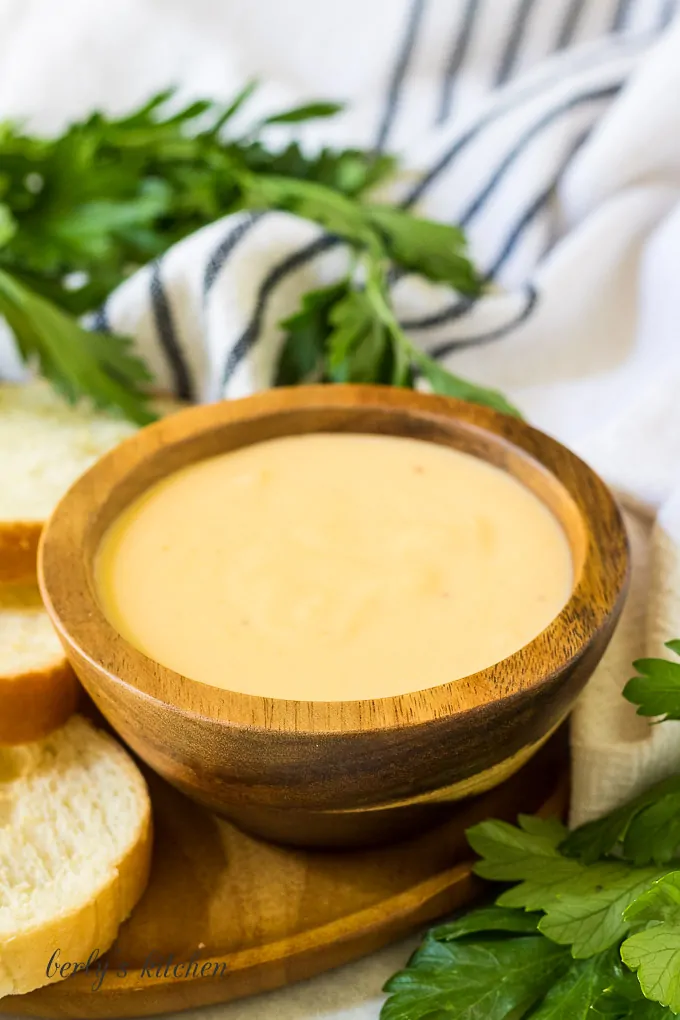 A small bowl of beer cheese dip served with chips.