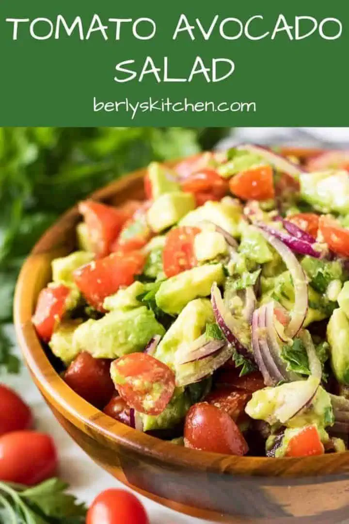 The tomato avocado salad served in a decorative wooden bowl.