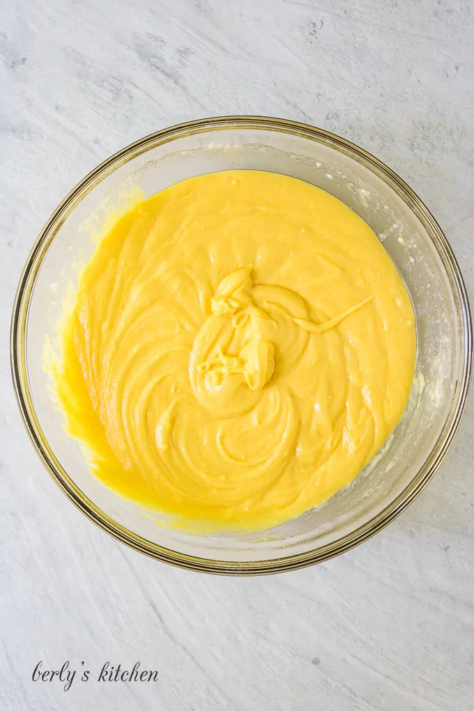 The yellow cake batter in a large glass mixing bowl.