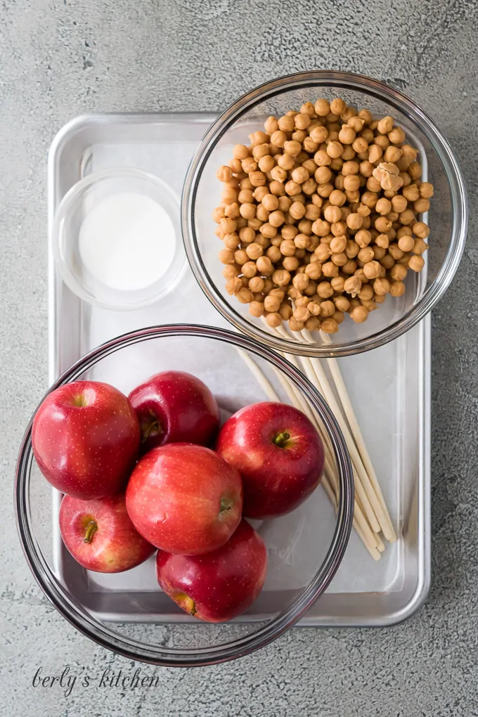 Apples, heavy cream, and other ingredients on a sheet pan.