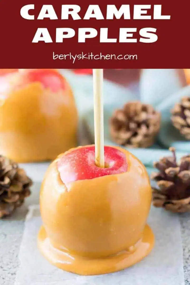 The caramel apple cooling on wax paper with fall decor.