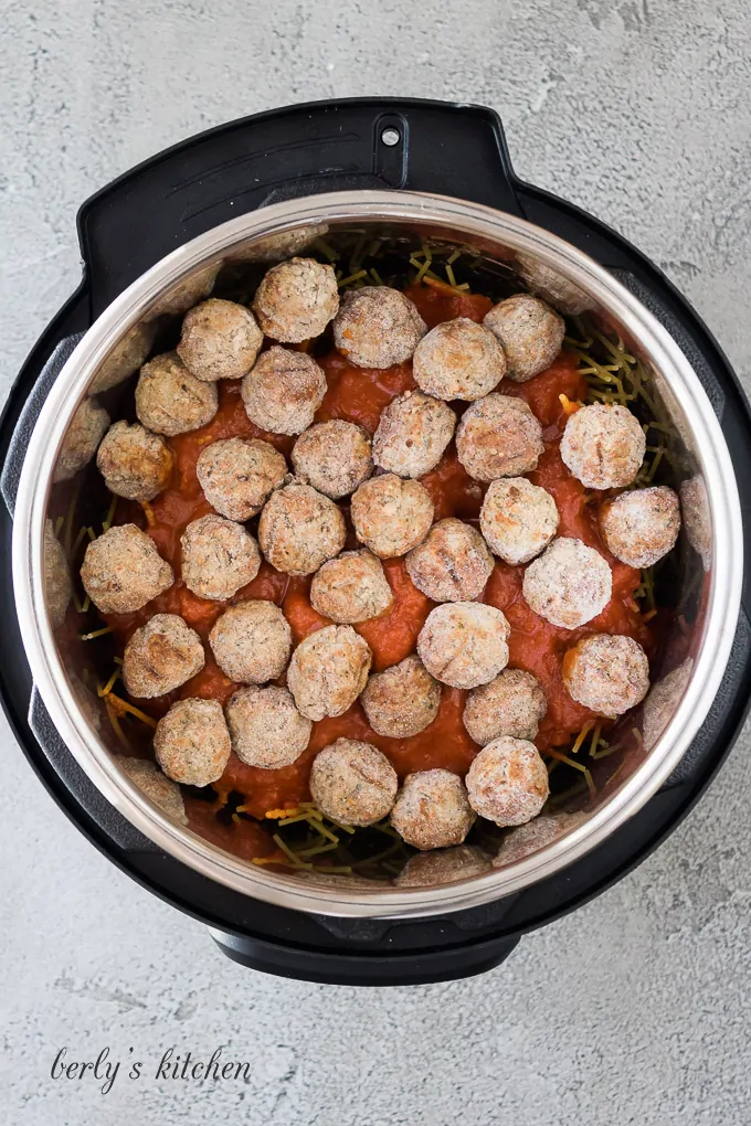 Pasta sauce and meatballs have been added to the noodles.