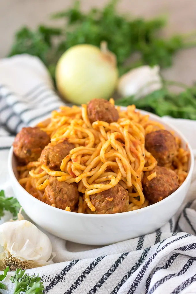 The spaghetti with meatballs served in a decorative white bowl.