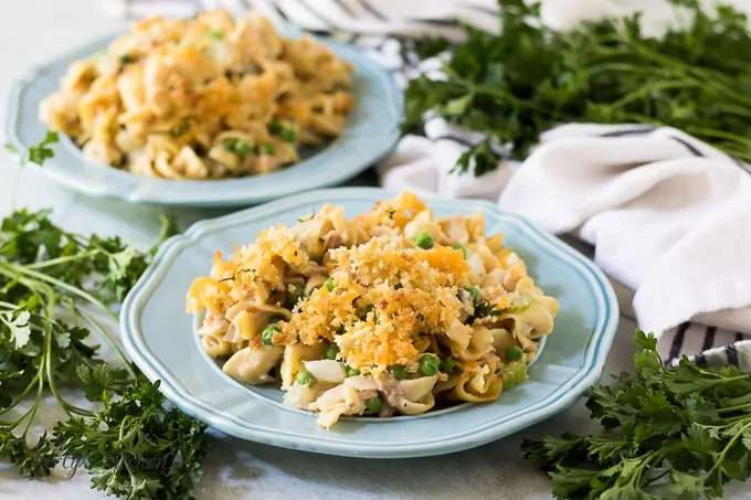 Two plates of the tuna casserole topped with panko breadcrumbs.