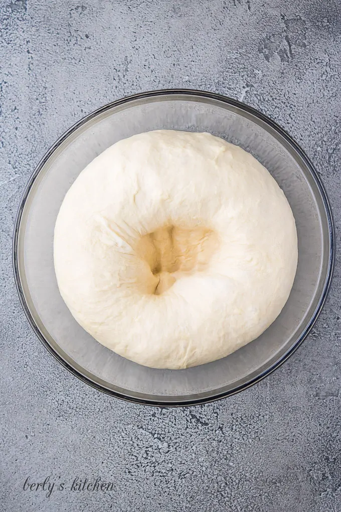 Punching down the dough to deflate it before making rolls.