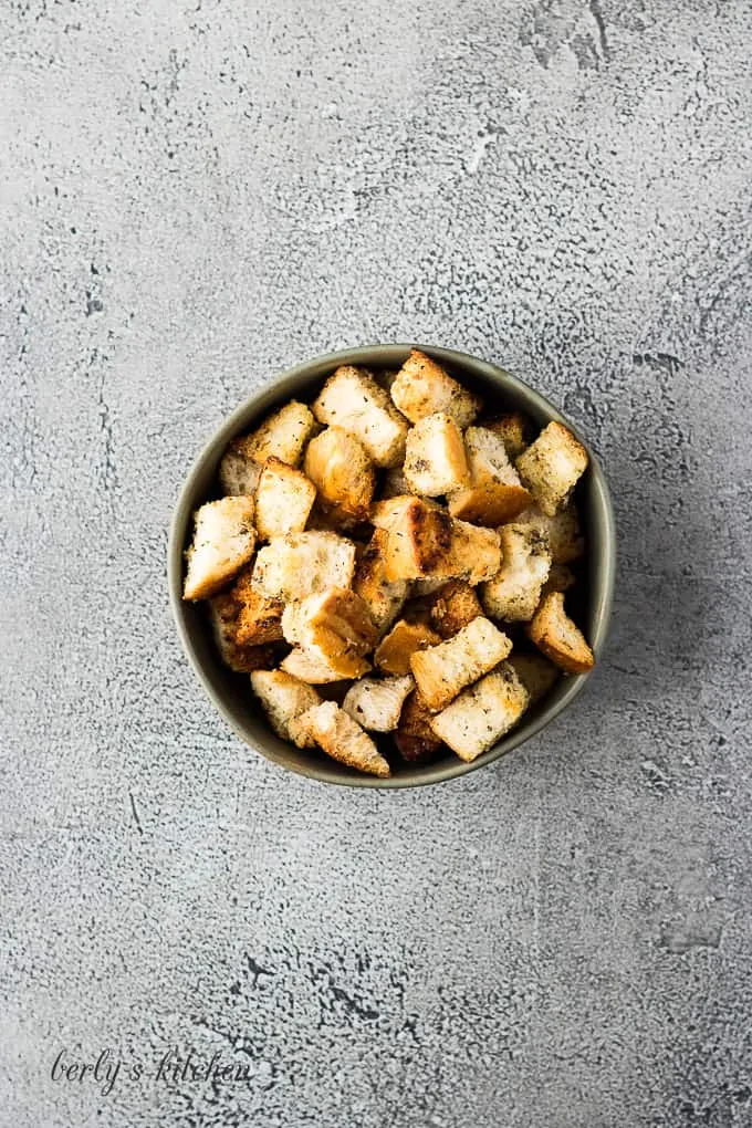 An aerial view of the finished buttery croutons in a bowl.