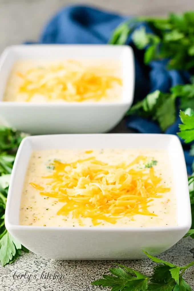 Two square bowls filled with the finished broccoli cheese soup.