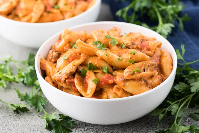 A bowl of the creamy shells and beef garnished with parsley.