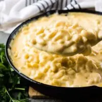 The macaroni and cheese being scooped from the iron skillet.