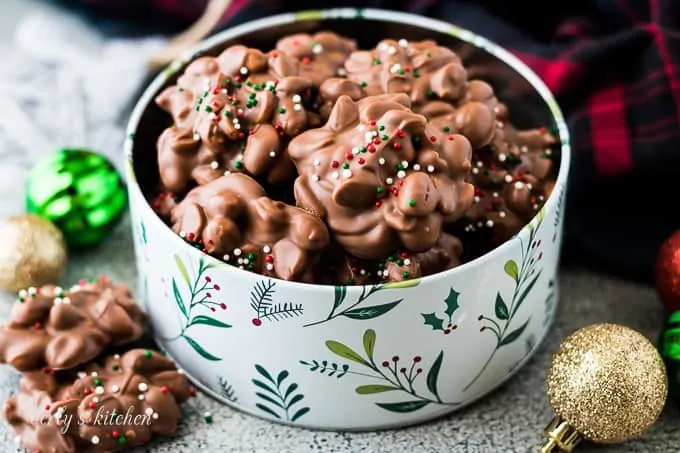 Crockpot candy topped with sprinkles in a decorative cookie tin.