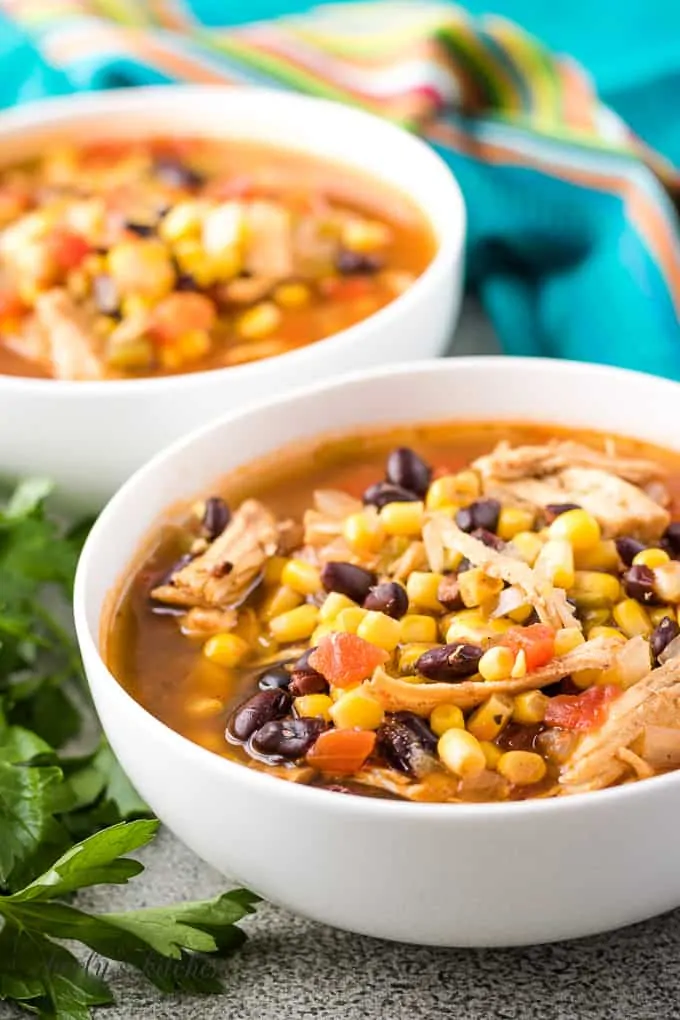 The finished chicken tortilla soup served in large white bowls.