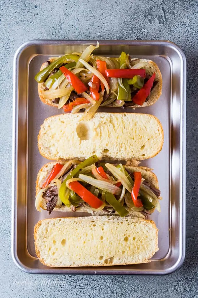 Shredded beef, onions, and peppers on a sliced hoagie bun.