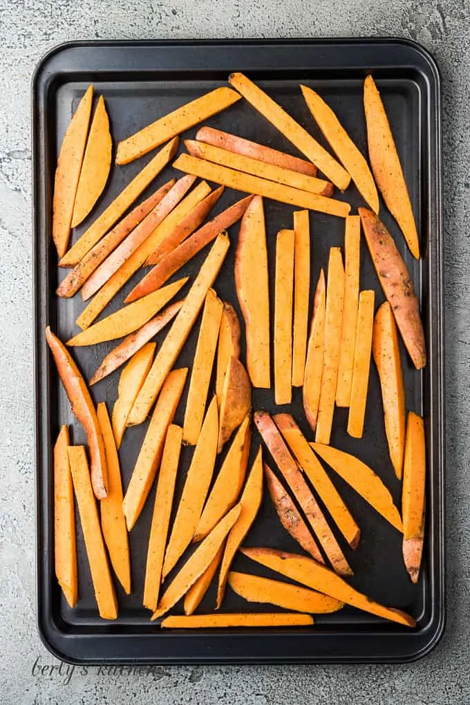 Sweet potato fries on a large sheet pan.