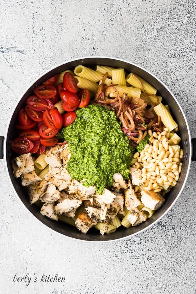 Chicken, pesto sauce and other ingredients in a large pan.