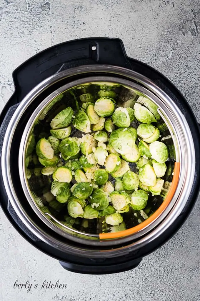 The steamer basket, veggies, and water in the cooker liner.