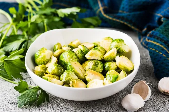 The finished instant pot brussel sprouts in a white bowl.