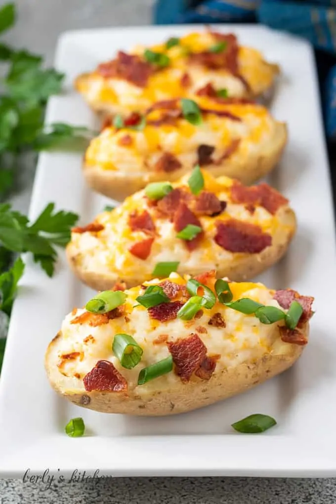 The potatoes topped with cheese, bacon, and sliced green onions.