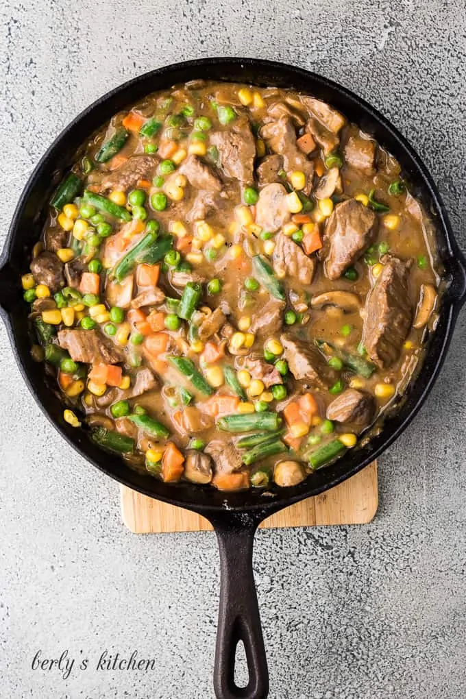 The frozen vegetables have been added to the gravy mixture.