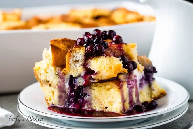 A piece of the french toast casserole drizzled with blueberry sauce.