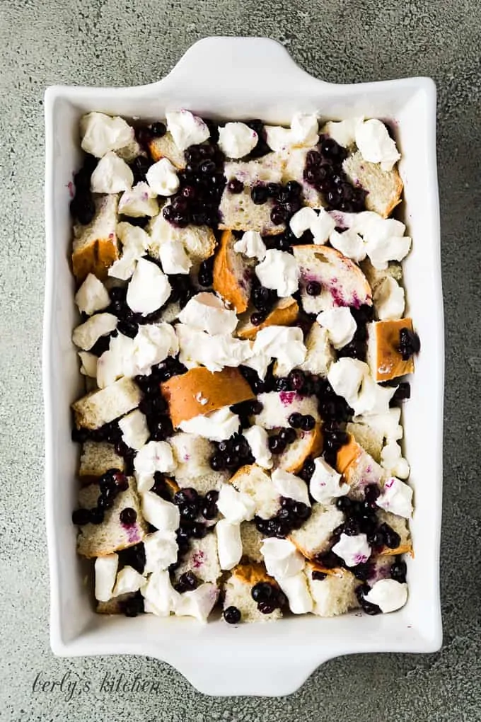 Cream cheese and blueberries have been added atop the bread.