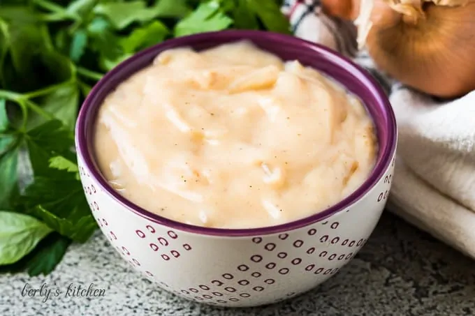 The cream of onion soup in a decorative purple bowl.