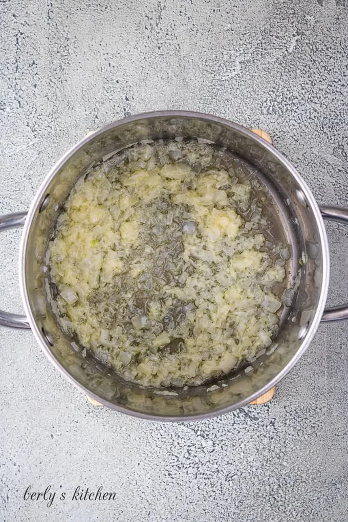 Diced onions and minced garlic cooking in a large saucepan.