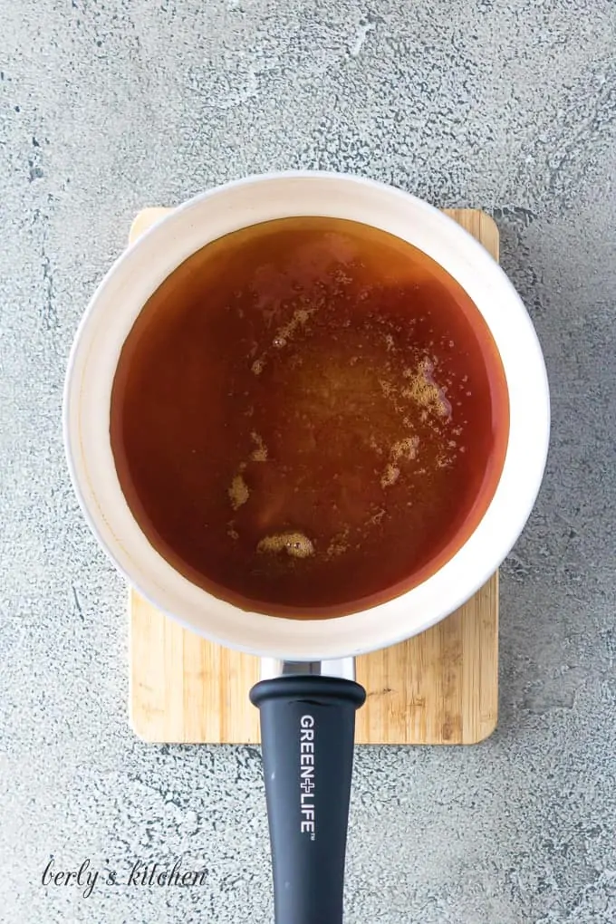 The caramel sauce cooking in a medium saucepan.