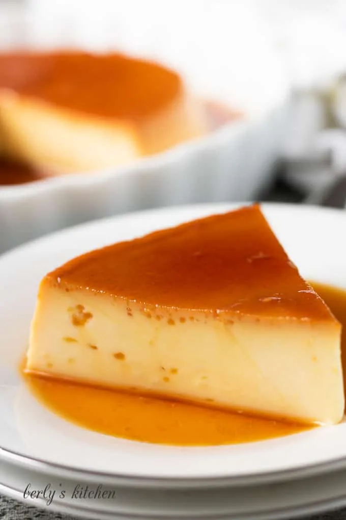 A slice of instant pot flan on a decorative plate.