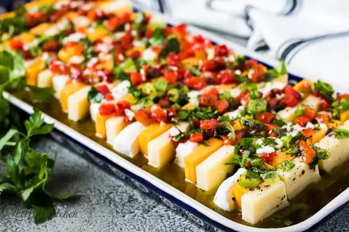 The finished marinated cheese served on a colorful rectangular plate.