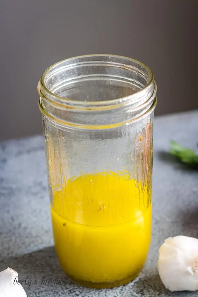 The orange salad dressing ingredients have been shaken until mixed.