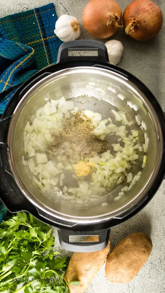 Garlic and spices have been added to the sauteed onions.