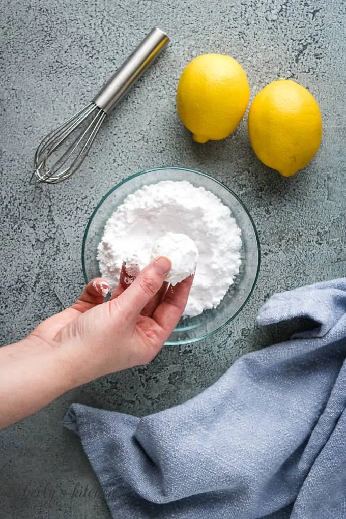 A ball of lemon cookie dough dipped into powdered sugar.