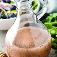 The finished salad dressing with a bowl of salad.