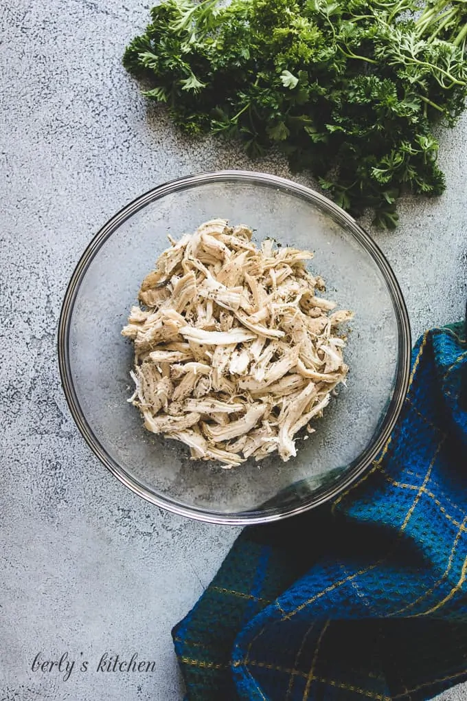 The chicken has been shredded and placed into a mixing bowl.