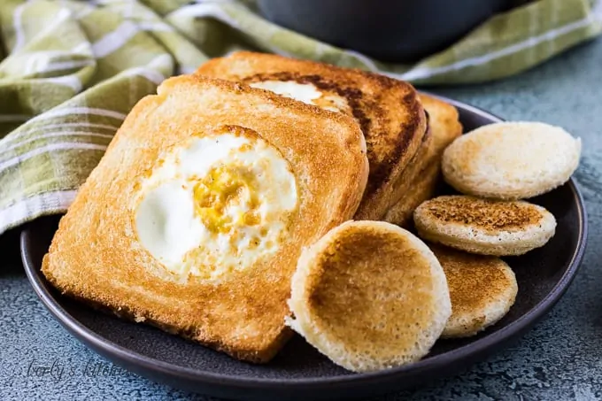 Four pieces of toast with fried eggs in the center.