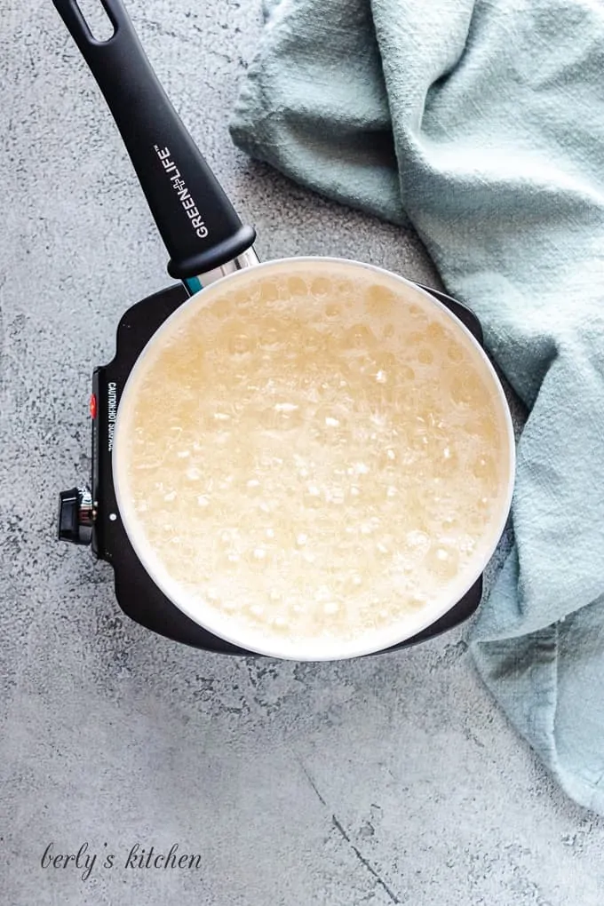 The sugar mixture has come to a boil in the pan.