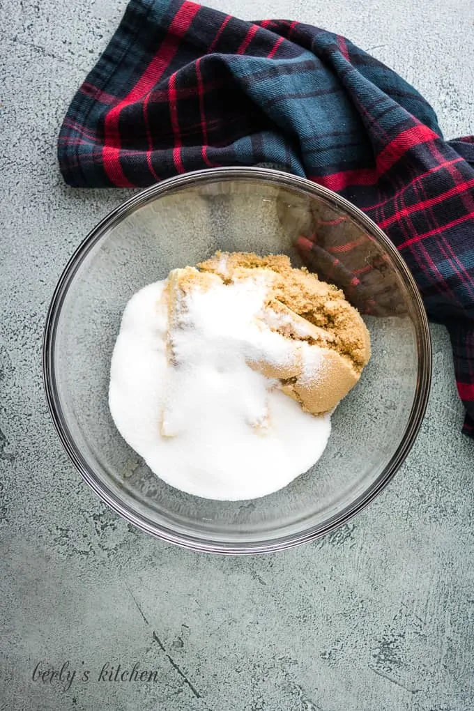 Brown sugar, granulated sugar, and softened butter in a bowl.