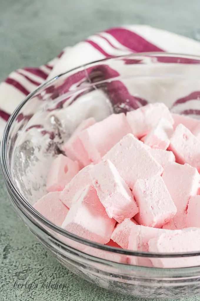 The sliced marshmallows being tossed with powdered sugar.