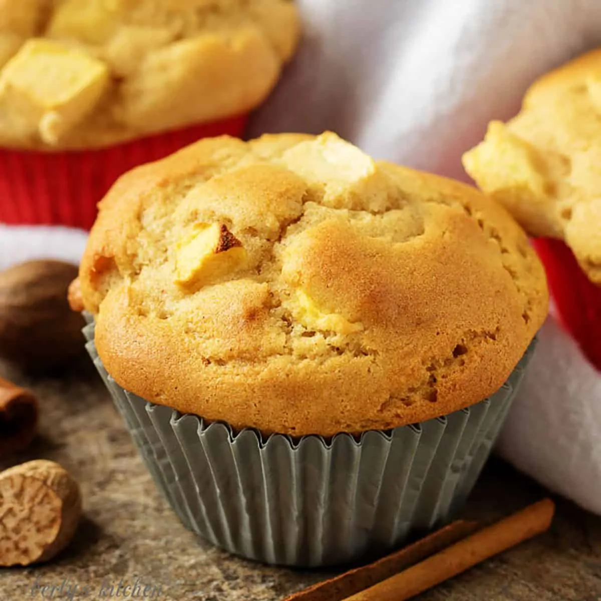 Apple cinnamon muffins with a cinnamon stick and fresh nutmeg.