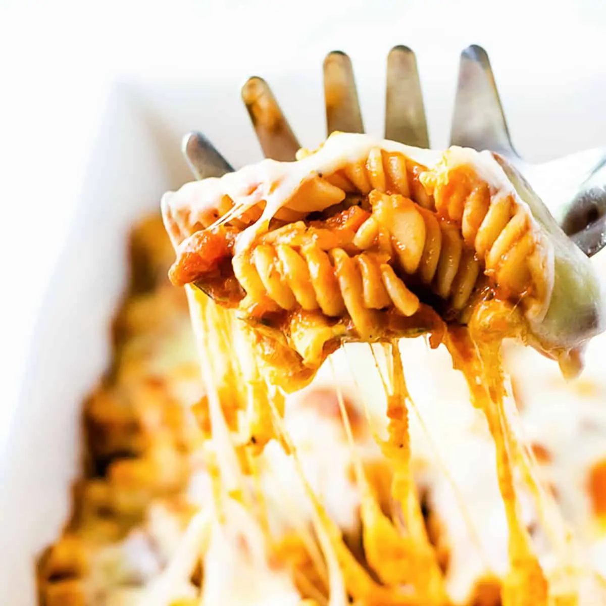 Cheesy pasta bake on a pasta scoop.