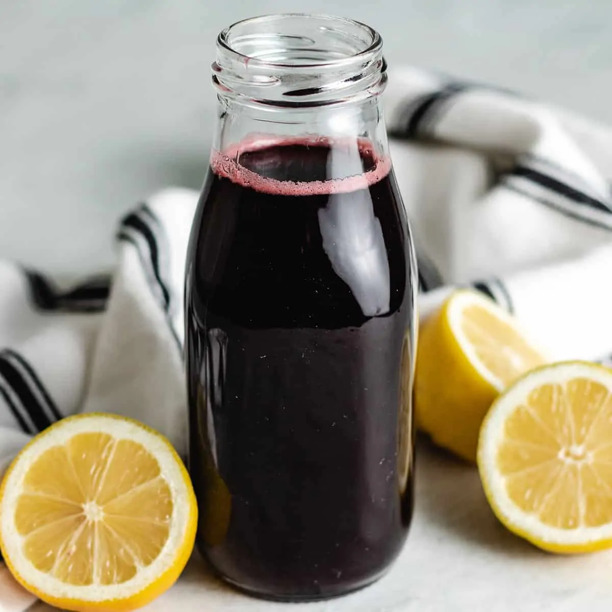 The cherry simple syrup in a decorative bottle.