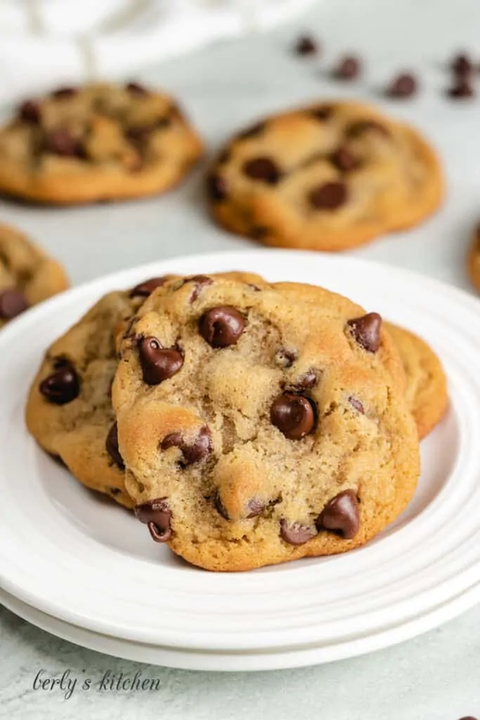 Three soft chocolate cookies on a small white plate.