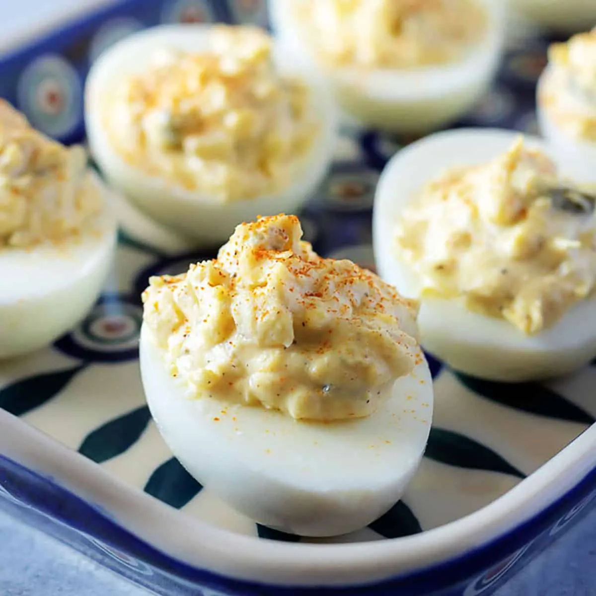 Classic deviled eggs on a blue and white platter.