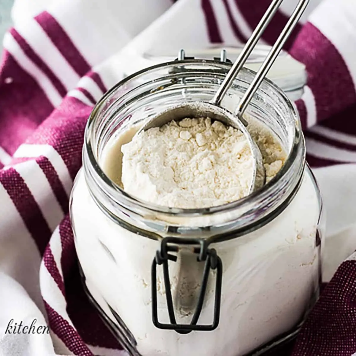 Jar filled with homemade baking mix and a measuring cup.